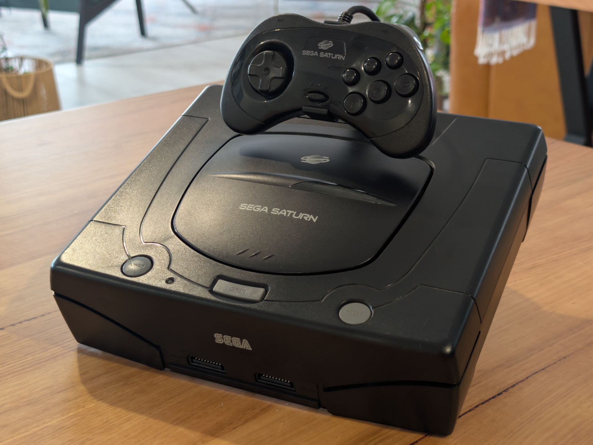 Sega Saturn konsol med kontroller uppifrån – placerad på displayställ