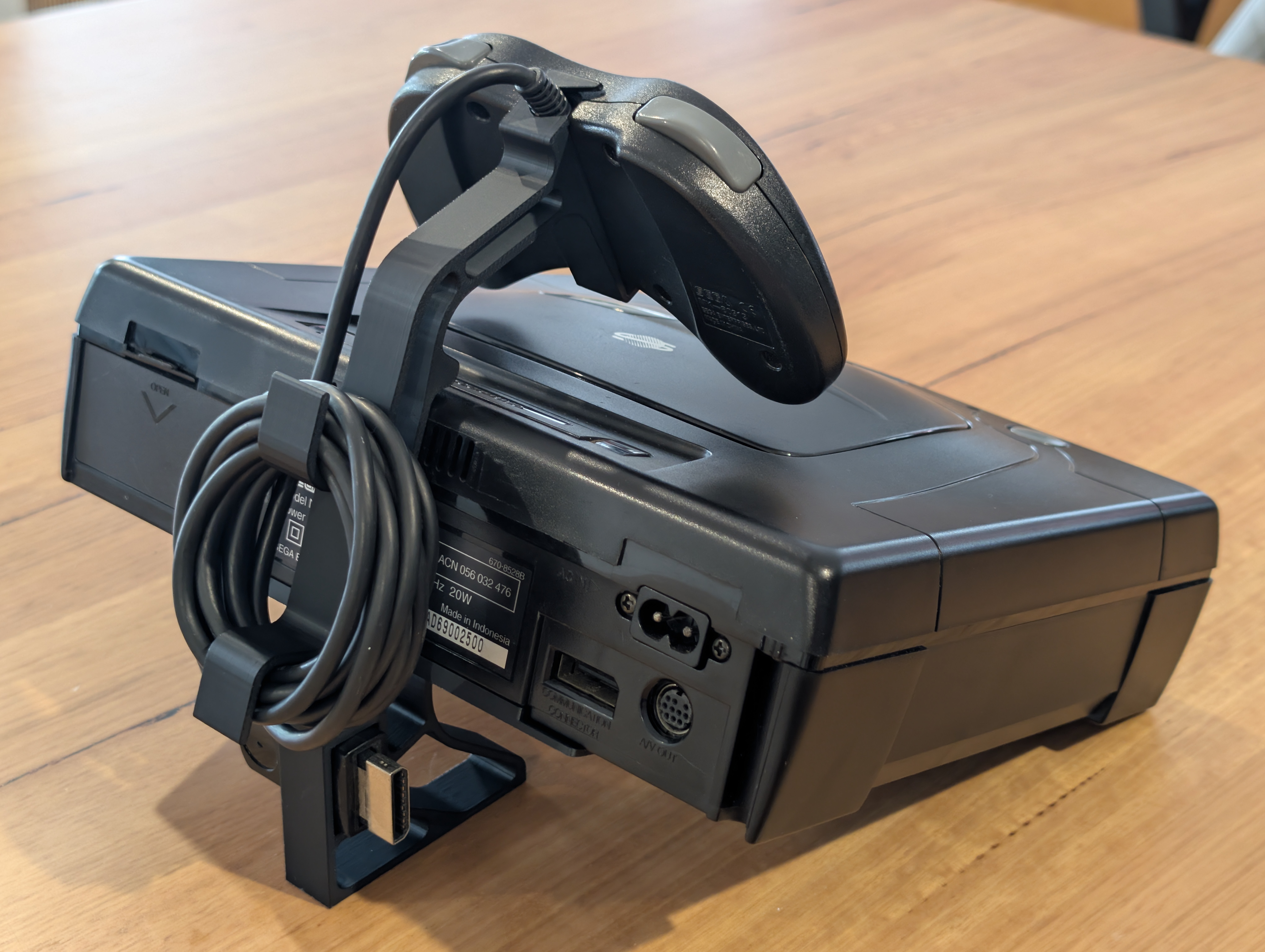 Sega Saturn bakifrån på ställ – kablar och anslutningar synliga