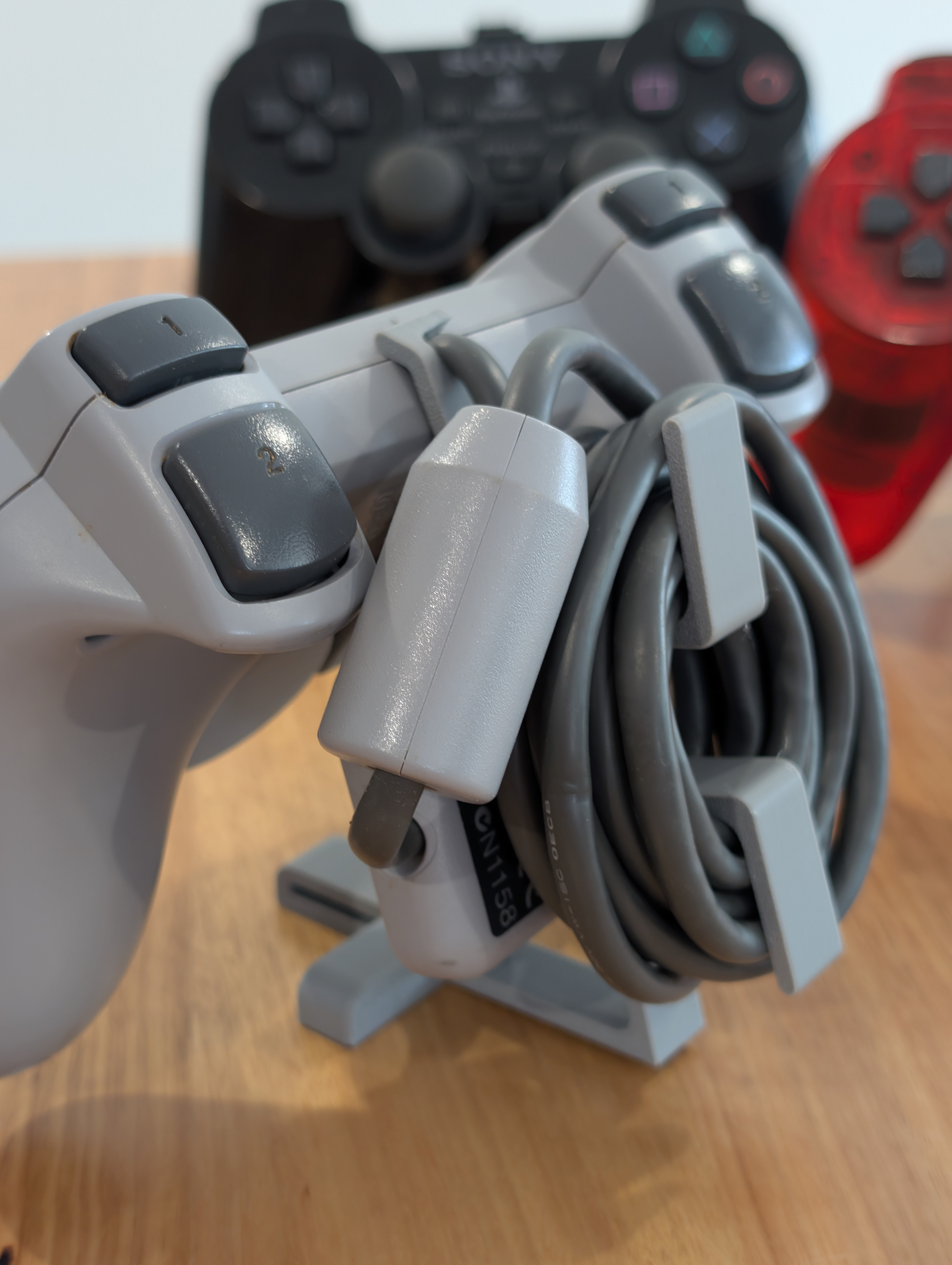 DualShock kontrollerställ närbild – kabelvinda och kontakthållare på baksidan